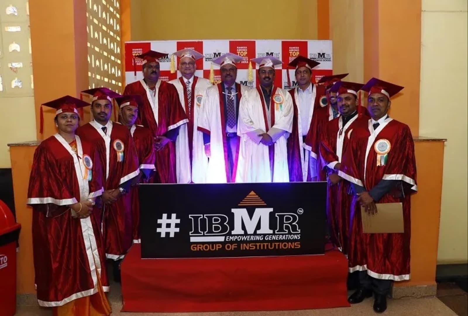 IBMR Group of Institutions faculty and guests in convocation robes on stage