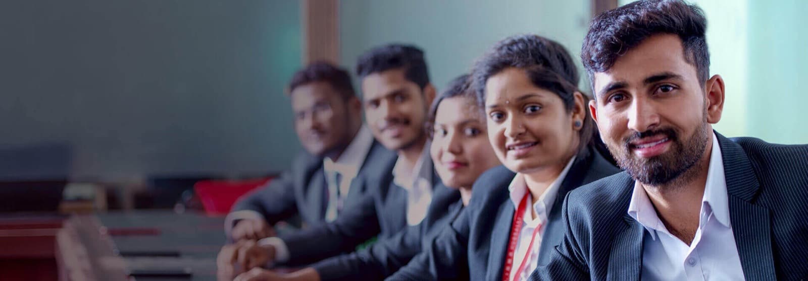 IBMR students in business suits seated around a boardroom table